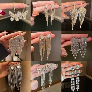 Close-up of luxury U-shaped pearl tassel earrings with rhinestones and butterfly designs