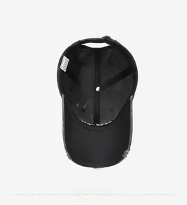 Interior view of black cotton baseball cap showing 100% cotton label and adjustable strap