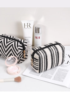 Close-up of woven makeup bags showing premium geometric patterns and gold zippers