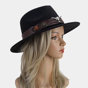 Détail d'un chapeau de cowboy en feutre noir avec bande en cuir et ornement taureau