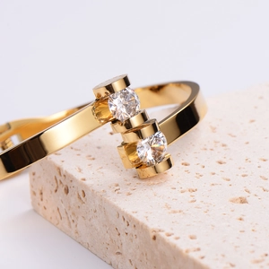 Elegant gold-plated stainless steel open bangle featuring two large sparkling round zircons