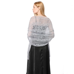 Detail of grey hollow lace shawl featuring elegant paisley patterns and long tassel fringe