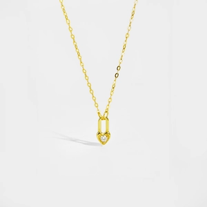 Detail of S925 silver heart lock necklace with pavé diamond center in golden finish