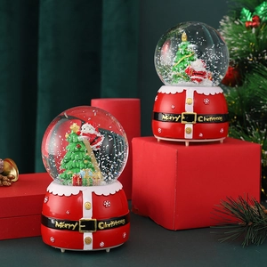 Detailed view of two Christmas snow globe music boxes with Santa and Xmas tree