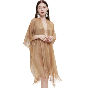 Detail of gold metallic mesh fabric featuring long fringe tassels on a summer shawl