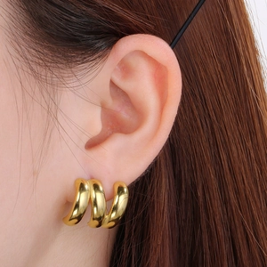 Detailed close-up of minimalist triple-layered gold C-hoop earrings on model