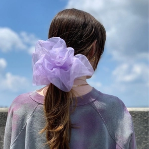 Oversized light purple organza scrunchie on low ponytail with outdoor sky background