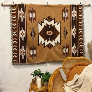 Detail of bohemian geometric woven blanket with fringe texture on a textured wall