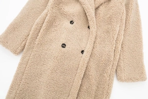Detail of warm beige teddy fleece coat with large lapel and double-breasted buttons
