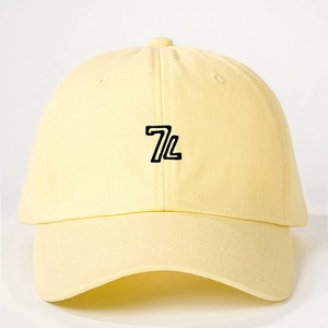Close-up of embroidered black 7L logo on a high-quality yellow cotton baseball cap