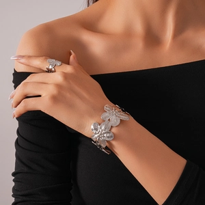 Silver flower jewelry set featuring textured matte finish bracelet and ring on model