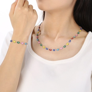 Colorful bow tie necklace and bracelet set worn by model in a minimalist resort style