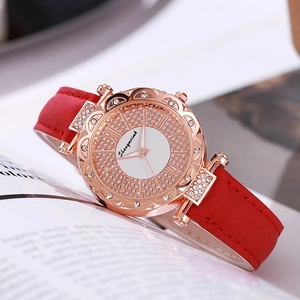 Elegant ladies quartz watch with red leather strap and rhinestone bezel on soft book background