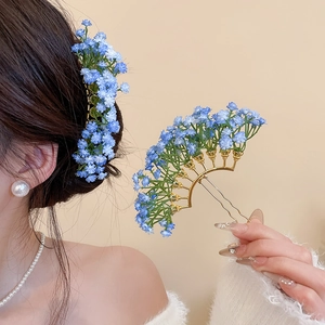 Detail of blue flower hair pin featuring elegant gold U-shaped metal fork for women