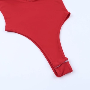 Detail view of red bodysuit crotch with functional snap buttons and premium stitching