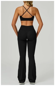 Détail d'un ensemble de yoga noir avec dos nu à brides et pantalon évasé taille haute