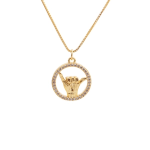 Dettaglio della collana con pendente gesto Shaka dorato e cornice di zirconi