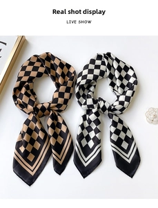 Detailed view of checkered silk scarves in khaki and black with elegant pearl decor