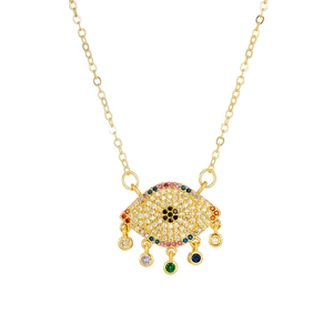 Macro detail of gold evil eye pendant with multi-colored zircons and hanging gemstones