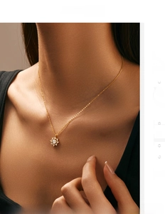 Gros plan d'un collier pendentif flocon de neige doré scintillant sur le cou d'un modèle