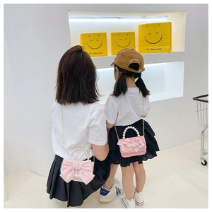 Détail de sacs en tweed pour filles avec anses en perles, nœuds roses et chaîne dorée