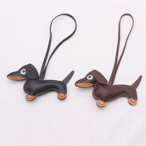 Detail of leather dachshund bag charms in black and brown with precise edge stitching