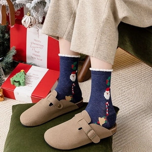 Christmas socks with Santa Claus pattern paired with light brown suede clogs in festive decor