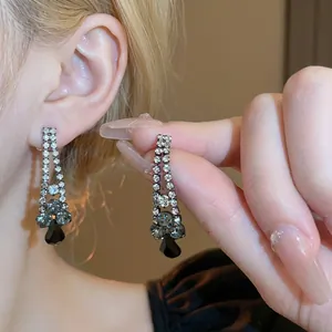 Elegant silver-toned droplet earring set with black and grey crystals on model