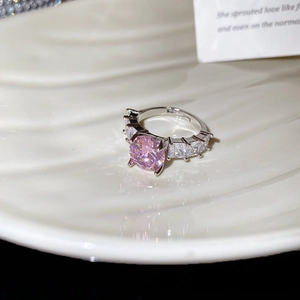 Macro shot of silver ring with large round pink gemstone and baguette zircon accents