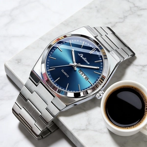Men's silver steel watch with blue gradient dial and date display on marble