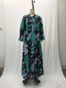 Detail of floral A-line dress featuring green abstract print and button-front closure