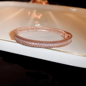 Detailed close-up of rose gold bangle with pave-set cubic zirconia and beaded edges