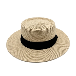 Detailed view of woven straw sun hat texture with elegant black ribbon trim