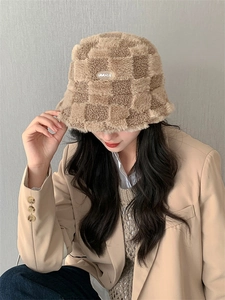 Détail du chapeau bob en laine d'agneau à damier marron et beige avec patch brodé