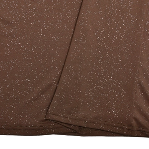 Detailed macro view of brown dress fabric with sparkling white glitter particles
