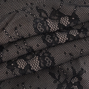 Detailed close-up of intricate black floral lace fabric with delicate mesh texture