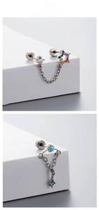 Macro detail of titanium steel chain earring with zircon star charms and studs