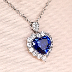 Elegant heart shaped sapphire necklace with shimmering white diamond accents and silver chain