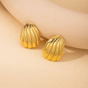 Detailed view of golden shell shaped stud earrings with elegant vertical textured stripes