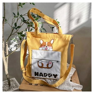 Detail of yellow canvas tote bag featuring a cute corgi print and zipped front pocket