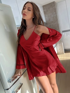 Détail d'un ensemble peignoir en satin rouge et nuisette avec bordures noires contrastées