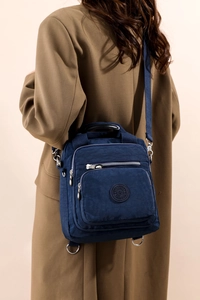 Sac bandoulière en nylon bleu multi-compartiments porté par un mannequin en extérieur