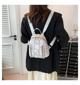 White PU leather backpack with letter print and gold zippers shown on a model