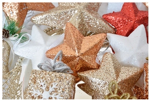 Glittering star and gift box Christmas tree ornaments in gold and red festive colors