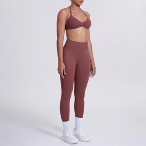 Dettaglio dei leggings yoga rosso mattone a vita alta e reggiseno sportivo allacciato