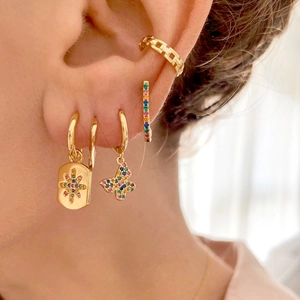 Golden butterfly earrings set with colorful zircon stones on woman's ear