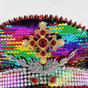 Close-up of rainbow sequin festival hat with golden cross, red gems and pearls