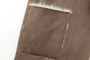 Detail van bruin imitatie suède jas met witte fleece rand op de vierkante zak