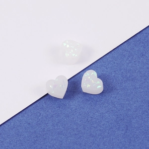 Macro view of three translucent heart-shaped resin charms with opal-like iridescent sequins