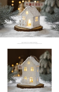 Macro detail of white LED Christmas house ornament with warm light on snow background